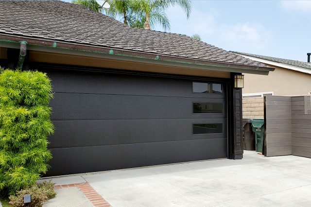 Black Skyline Flush garage door with long-panel windows installed for a remodeled home in Huntington Beach, CA